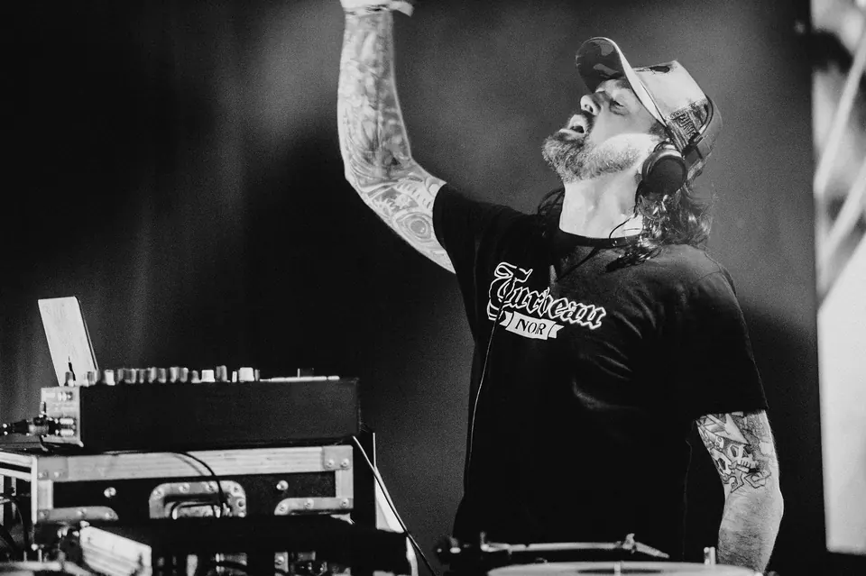 DJ Turbeau behind the decks with his arm raised at the Alcatraz Heavy Metal Party (De Warmste Week, 2019)